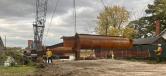 A crawler crane lifts a steel support structure for the temporary trestle bridge into place for construction access.   (Shirley-Branch Joint Venture team photo)