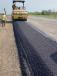 Workers used the material excavated for the project to raise the road in some places while eliminating hills in other places. The completed road is 15 ft. wide with 10-ft. shoulders.   (Photo courtesy of Shilling Construction)